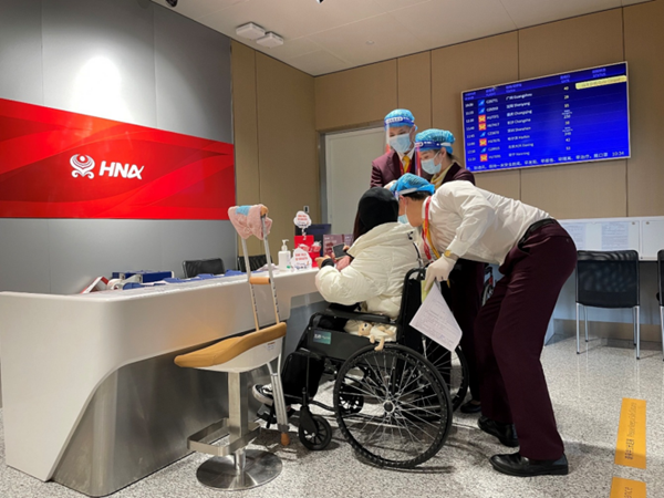 海南航空地服工作人员在特殊旅客服务专区为旅客提供帮助(尹翔宇/摄)
