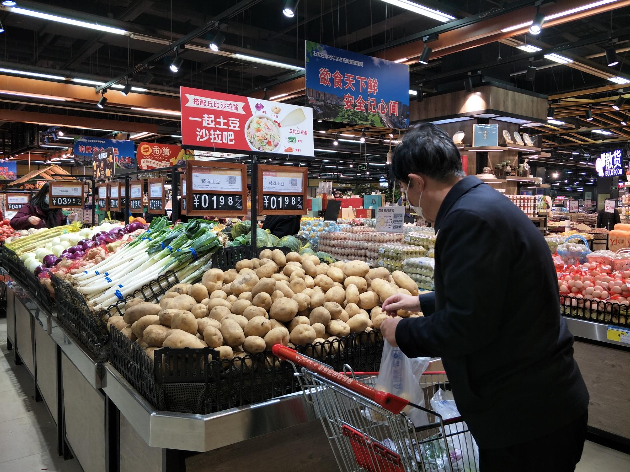 消费者在超市里选购土豆.李建/摄