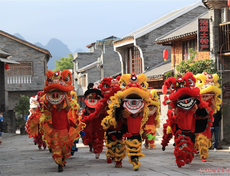 在柳州市鹿寨县中渡镇,一队传统民俗舞龙舞狮队伴随着锣鼓声声穿越于