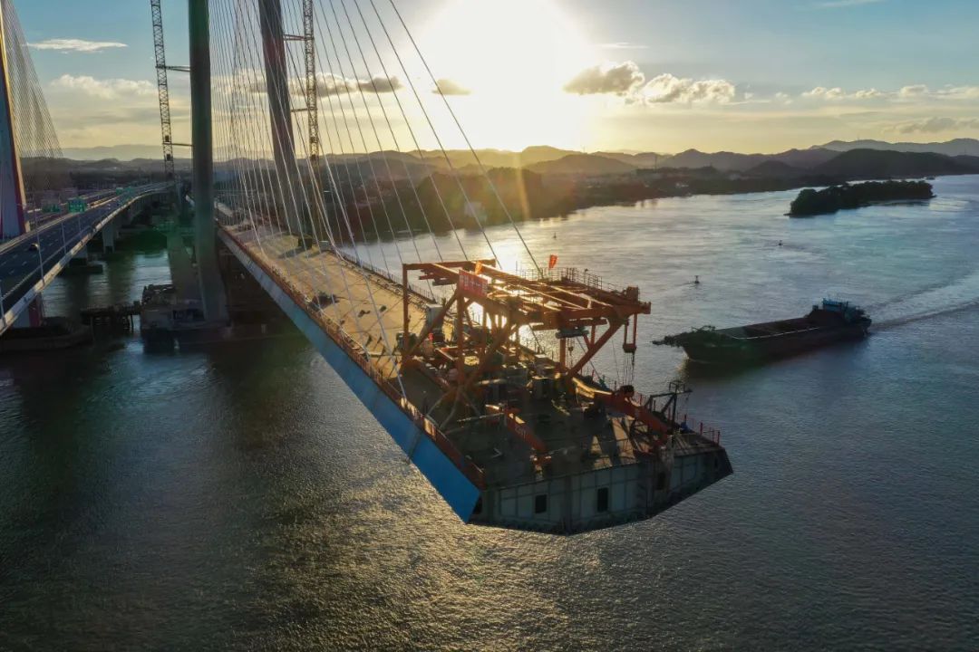 2020年6月19日拍摄的广州南沙港铁路跨西江特大斜拉桥钢箱梁吊装和斜拉索施工现场（无人机照片）。刘大伟摄（新华社）