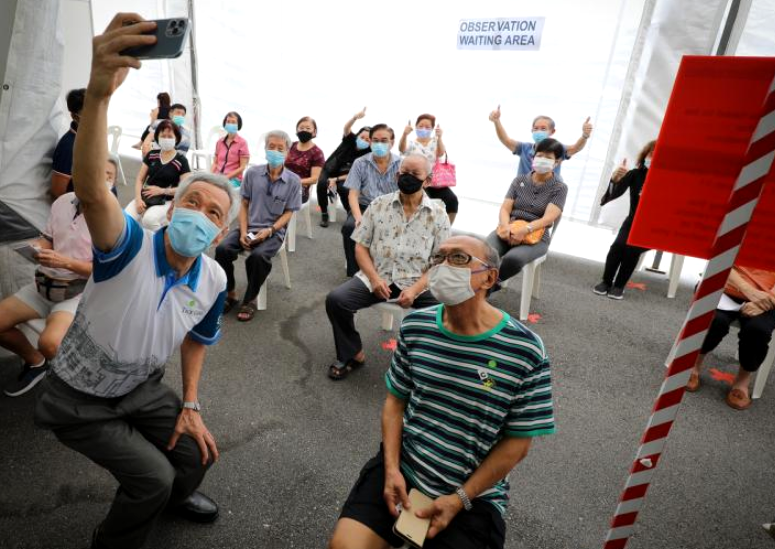 △新加坡总理李显龙与接种疫苗的民众合影
