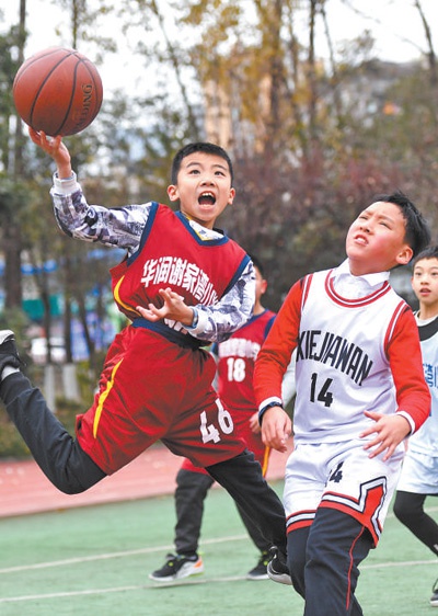 图为重庆市九龙坡区谢家湾小学学生在篮球场上打篮球.
