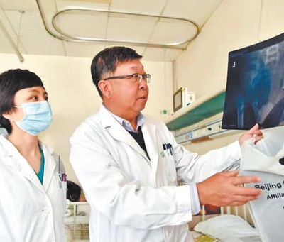 北京儿童医院骨科主任张学军(右)带领团队讨论脊柱侧弯患儿治疗犯案