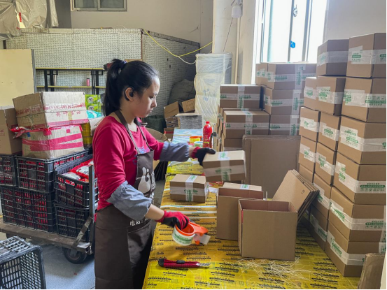 图说:林咸乐线面厂的工人正在包装,一个个包裹将福州线面发往全国各地