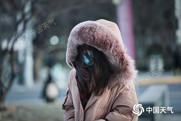 △北京昨天北风劲吹,行人全副武装出行。