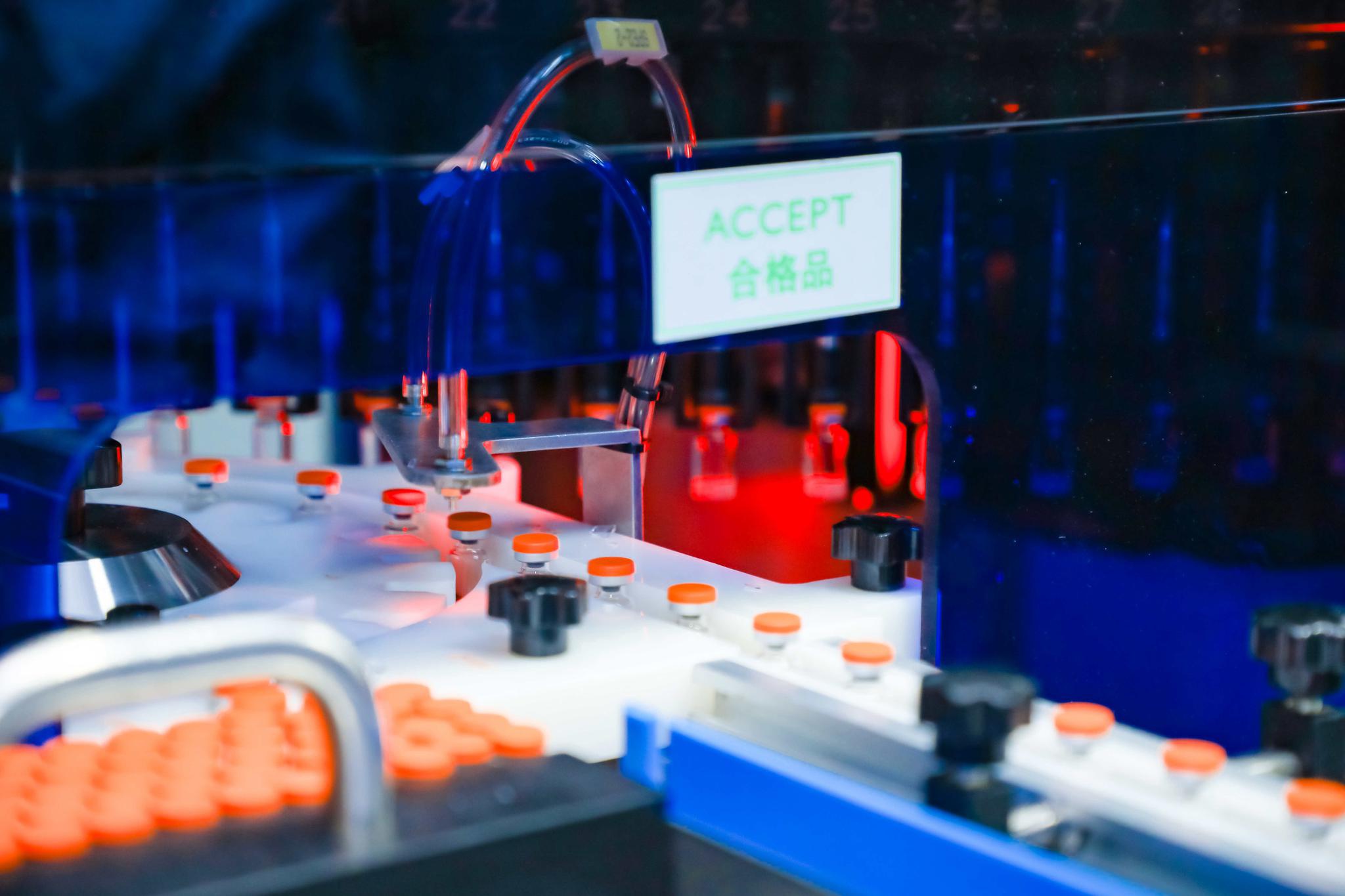 装了新冠灭活疫苗的西林瓶在进行灯检。科兴中维供图