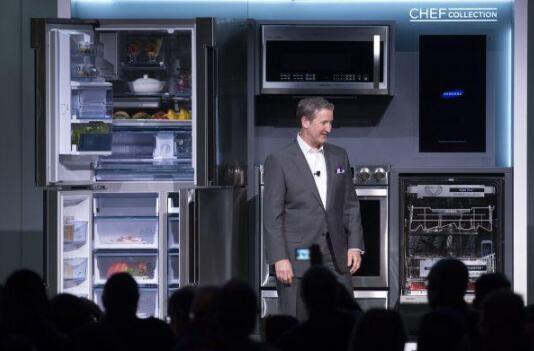 资料图：在美国拉斯韦加斯，三星美国公司副总裁约翰·赫林顿展示冰箱、洗衣机等新产品。(新华社)