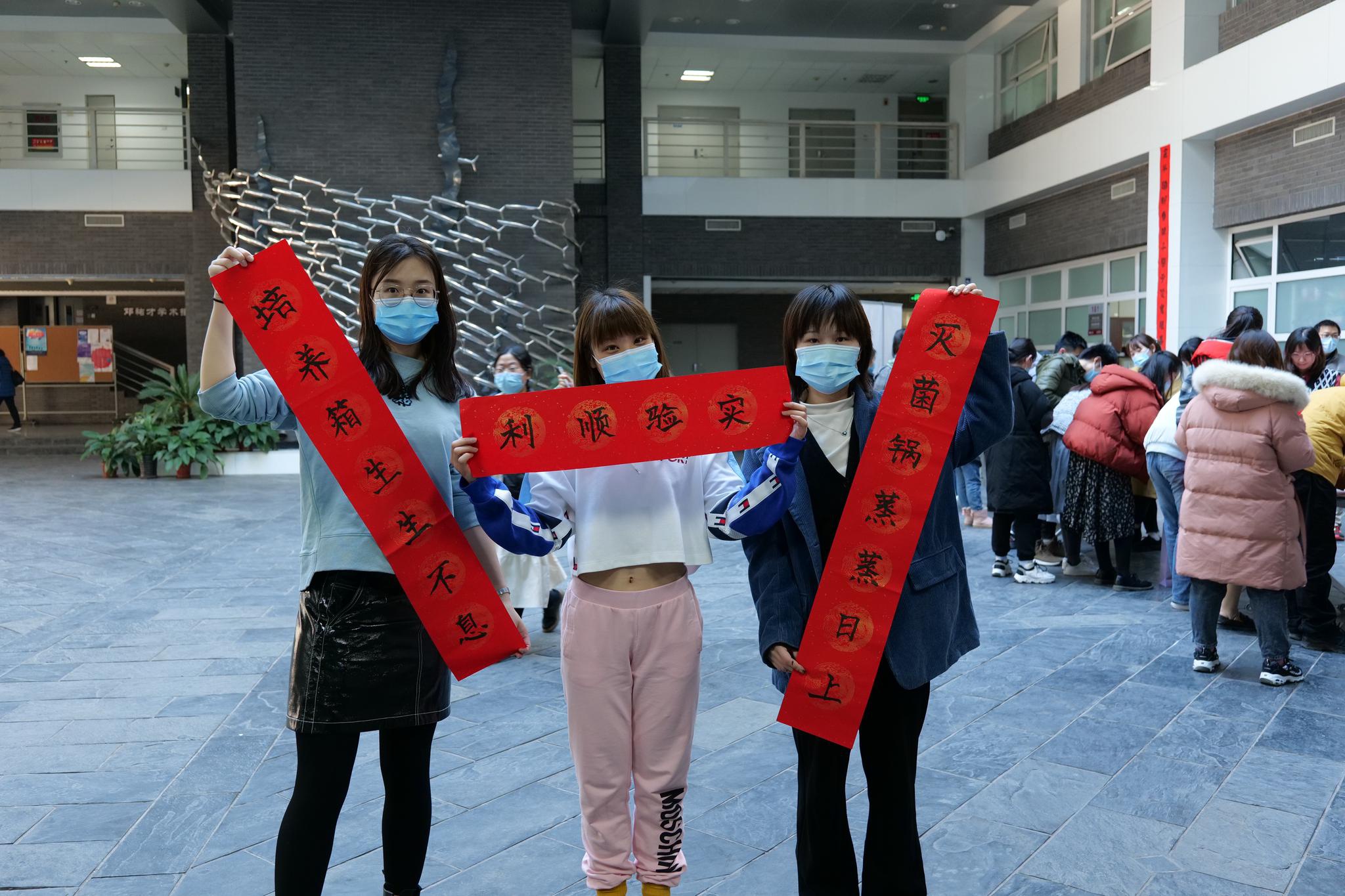 北京大学生科院学生展示自己写的对联.