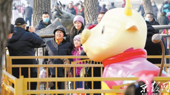 昨天上午，颐和园迎来了新春第一批游客，人们举家来到颐和园铜牛处合影，沾“牛气”。今年新添的卡通牛小昂，同样吸引了游客们。本报记者 刘平摄