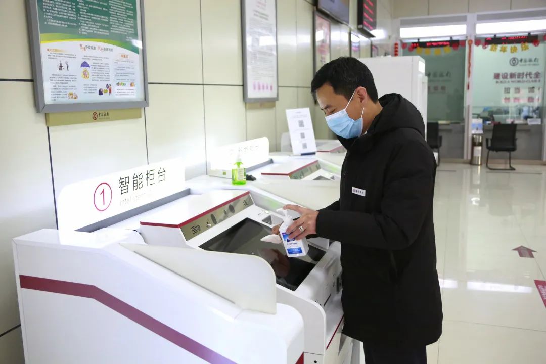 图为中国银行滁州分行营业部的员工为智能柜台消毒。