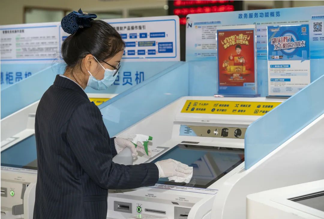 图为建设银行广东江门城区支行工作人员对自助设备进行消毒。