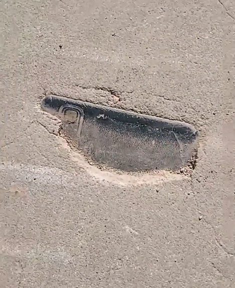 男子遛弯发现3年前丢的手机：竟镶嵌在水泥路里