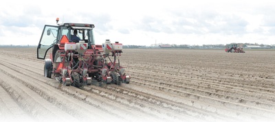 荷兰北荷兰省一片农田里，人们驾驶农机进行播种作业。