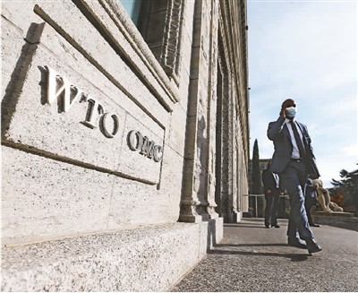 图为在瑞士日内瓦，一名代表抵达世贸组织准备参加会议。