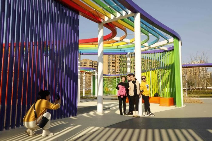 走进十里河上游河段的龙门公园,最先映入眼帘的"七色"彩虹廊架宛若