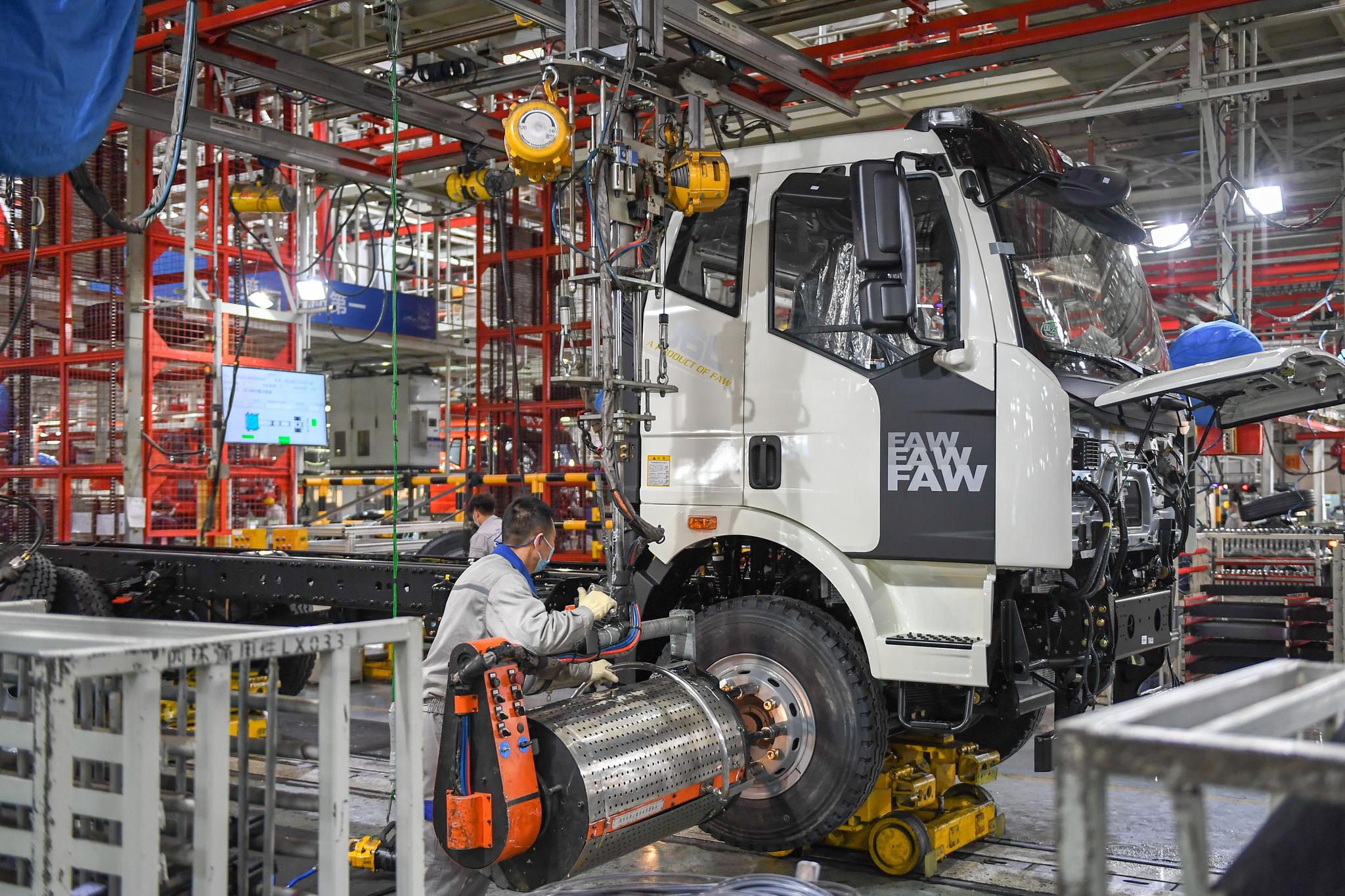 工人在位于长春的一汽解放总装车间装配车辆(2月2日摄).