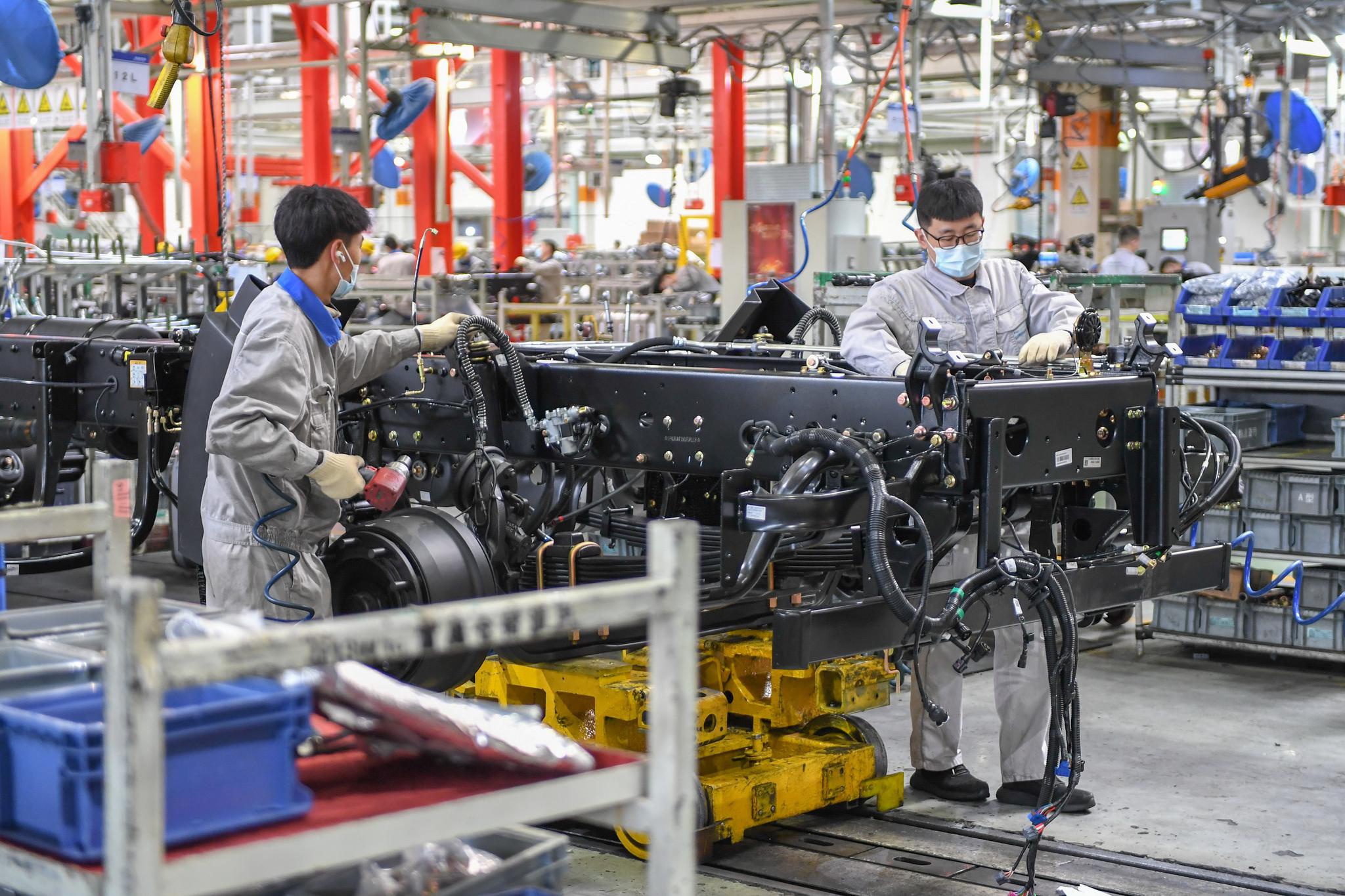 工人在位于长春的一汽解放总装车间装配车辆(2月2日摄).