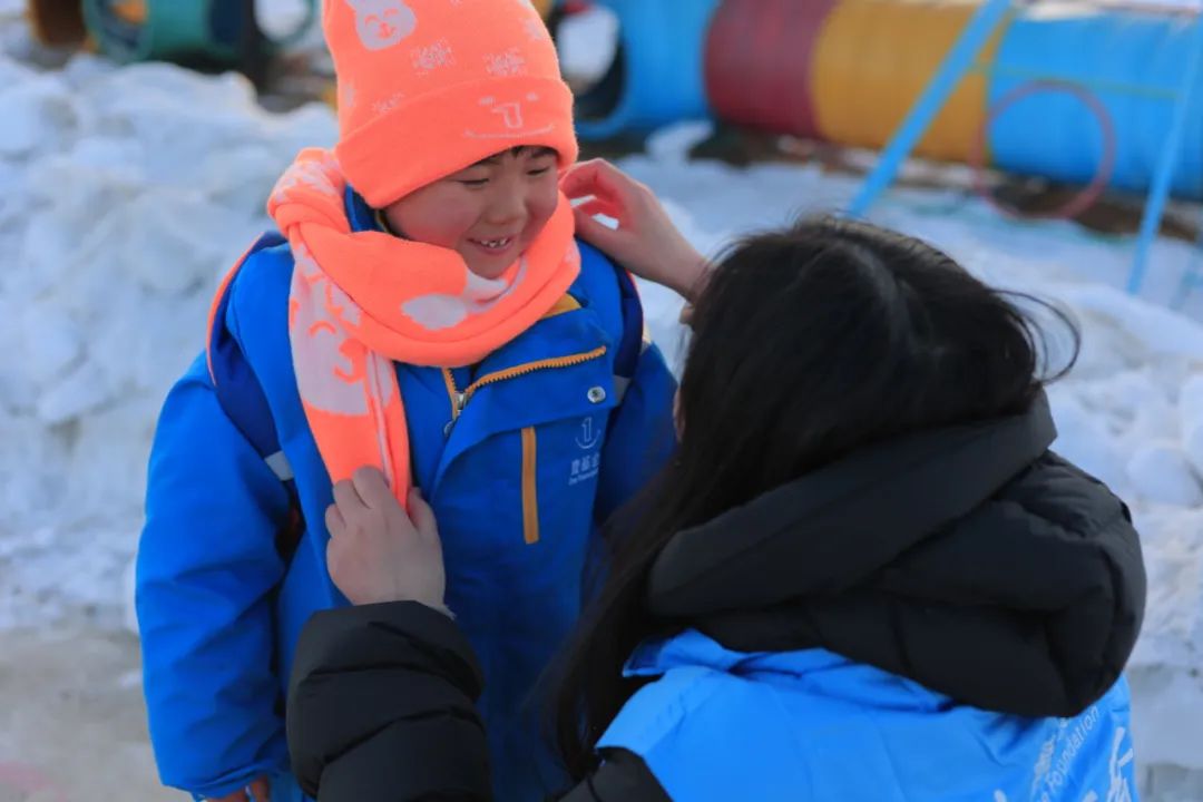 当志愿者为楠楠戴上帽子、系上围巾时,楠楠露出了灿烂的笑容。