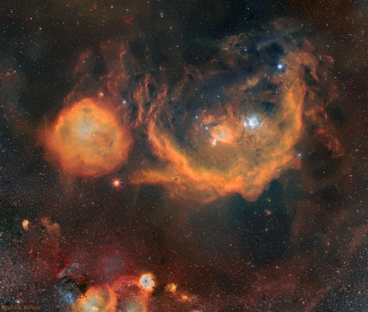 这颗红巨星看起来就像一颗红色的星在两团橙色云之间爆发。图片来源：Andrew Klinger