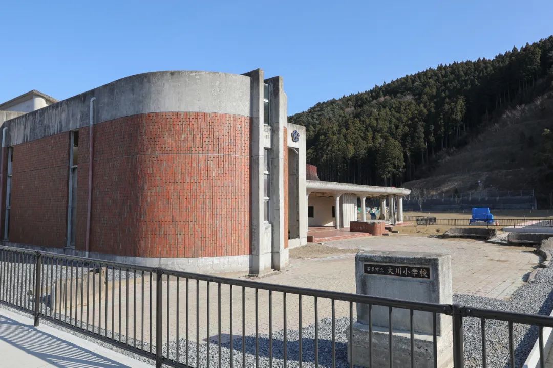 这是3月9日在日本宫城县石卷市拍摄的大川小学遗址和校园后方的山.