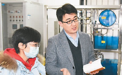 　　王友清（右）和同事在实验室进行业务讨论。　　新华社记者 李紫恒摄
