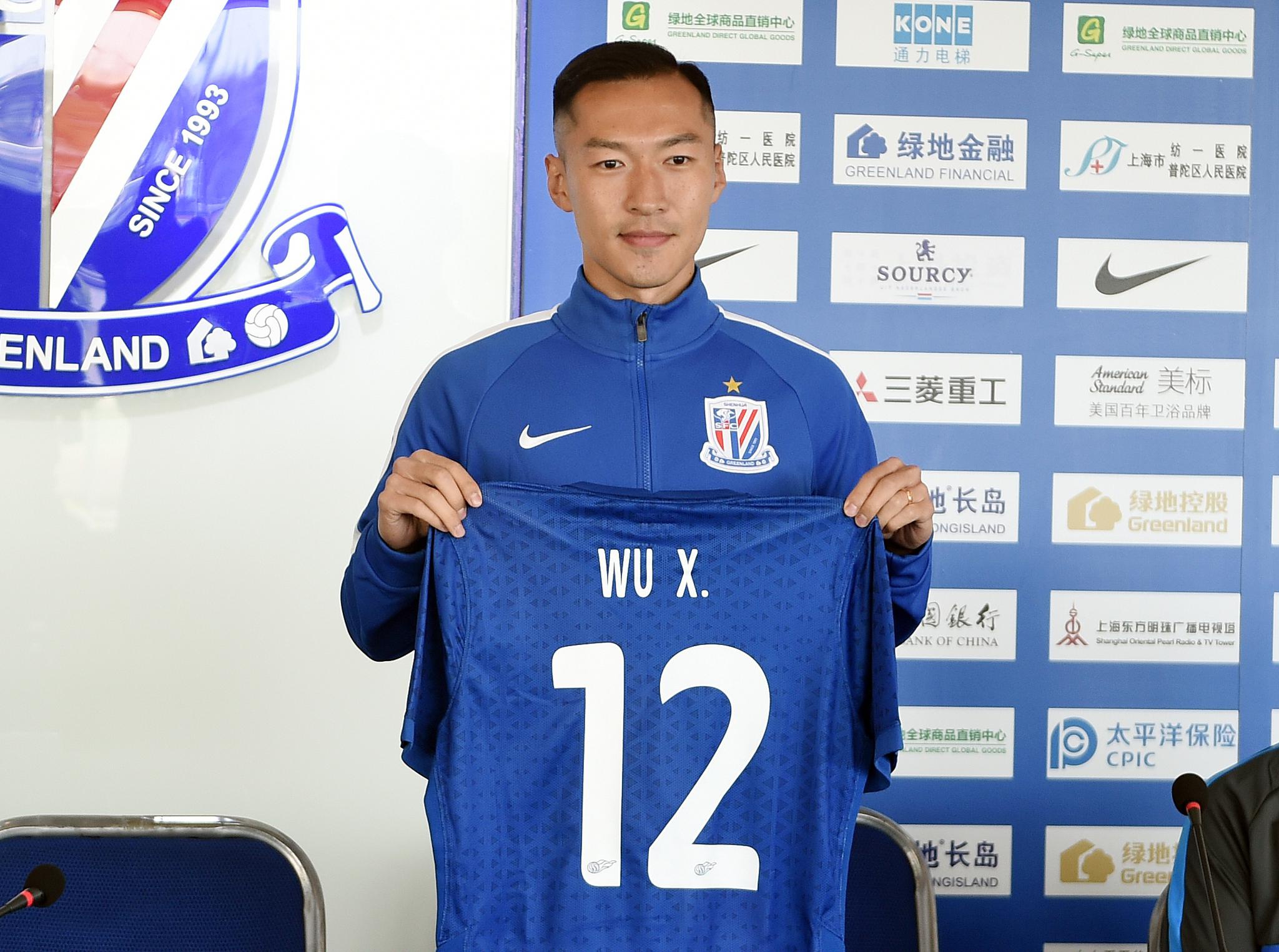 吴曦举起了申花12号球衣.