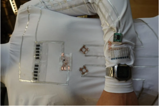 这种可穿戴微电网能够通过丝网印刷印在衣服上，为液晶手表和小型电子设备供电。图片来源：Lu Yin
