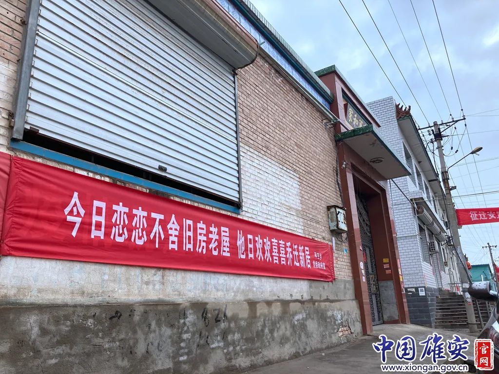 "今日恋恋不舍旧房老屋 他日欢欢喜喜乔迁新居"宣传横幅悬挂在村子