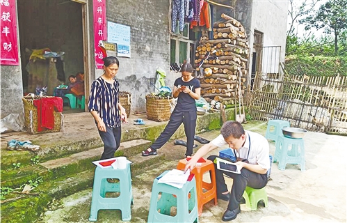 重庆渝北银座村镇银行客户经理在渝北区统景镇古路村用移动工作站为农户开办银行卡。 徐诗鸿摄