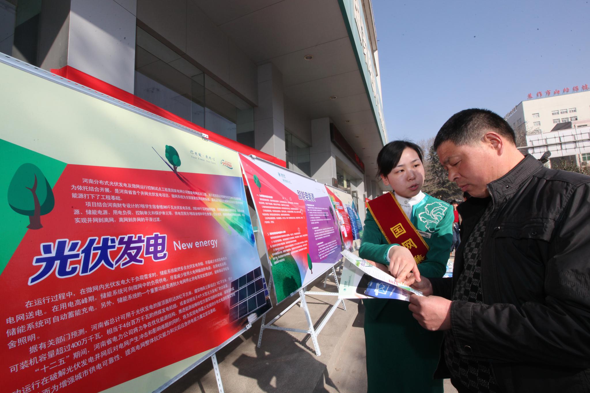 图为3月17日,国网焦作供电公司员工宣传光伏发电发展趋势,服务"双碳