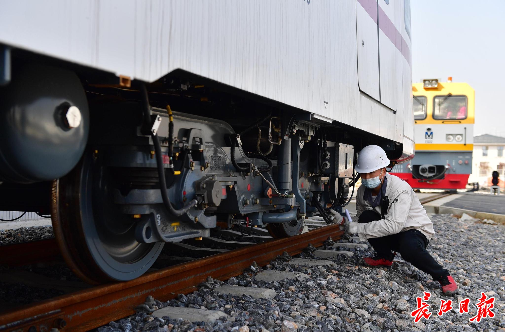 工作人员在检查吊装到轨道上的列车。记者李永刚 摄