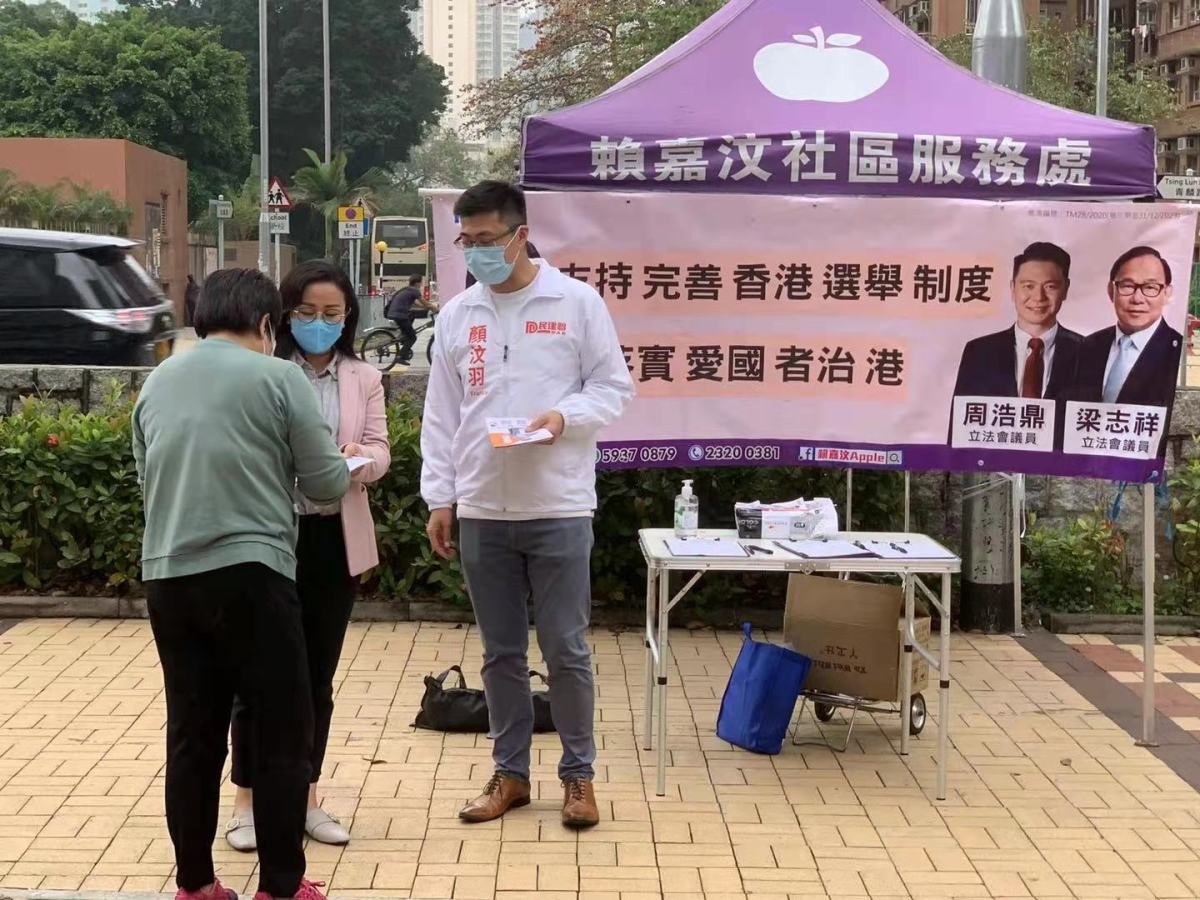 △香港民建联副秘书长颜汶羽（右）在屯门新田邨口参加街站活动，支持完善香港的选举制度。