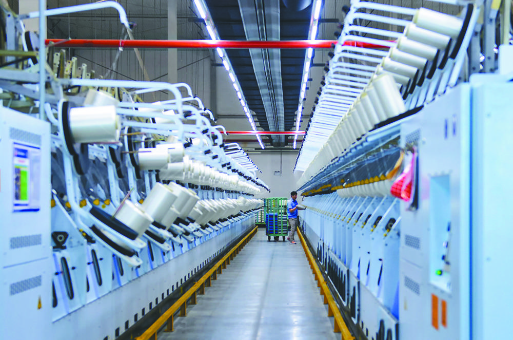 工人在平煤神马集团帘子布发展公司捻织车间内巡检设备工人在平高集团
