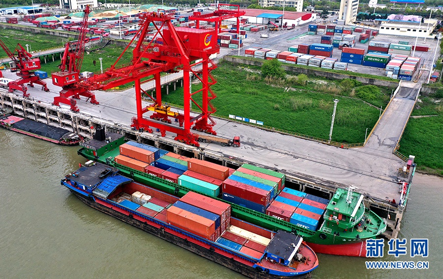 4月8日,在安徽铜陵港长江外贸码头,港口机械在装卸物资(无人机照片).