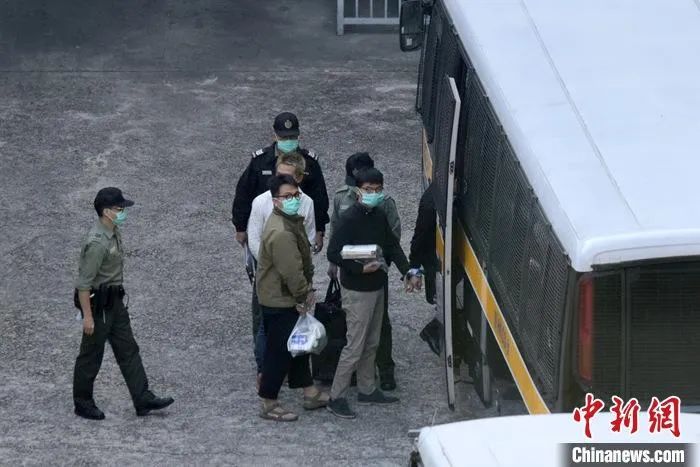 黄之锋(右一)及林朗彦(右二)在香港荔枝角收押所被押上惩教署车辆移送