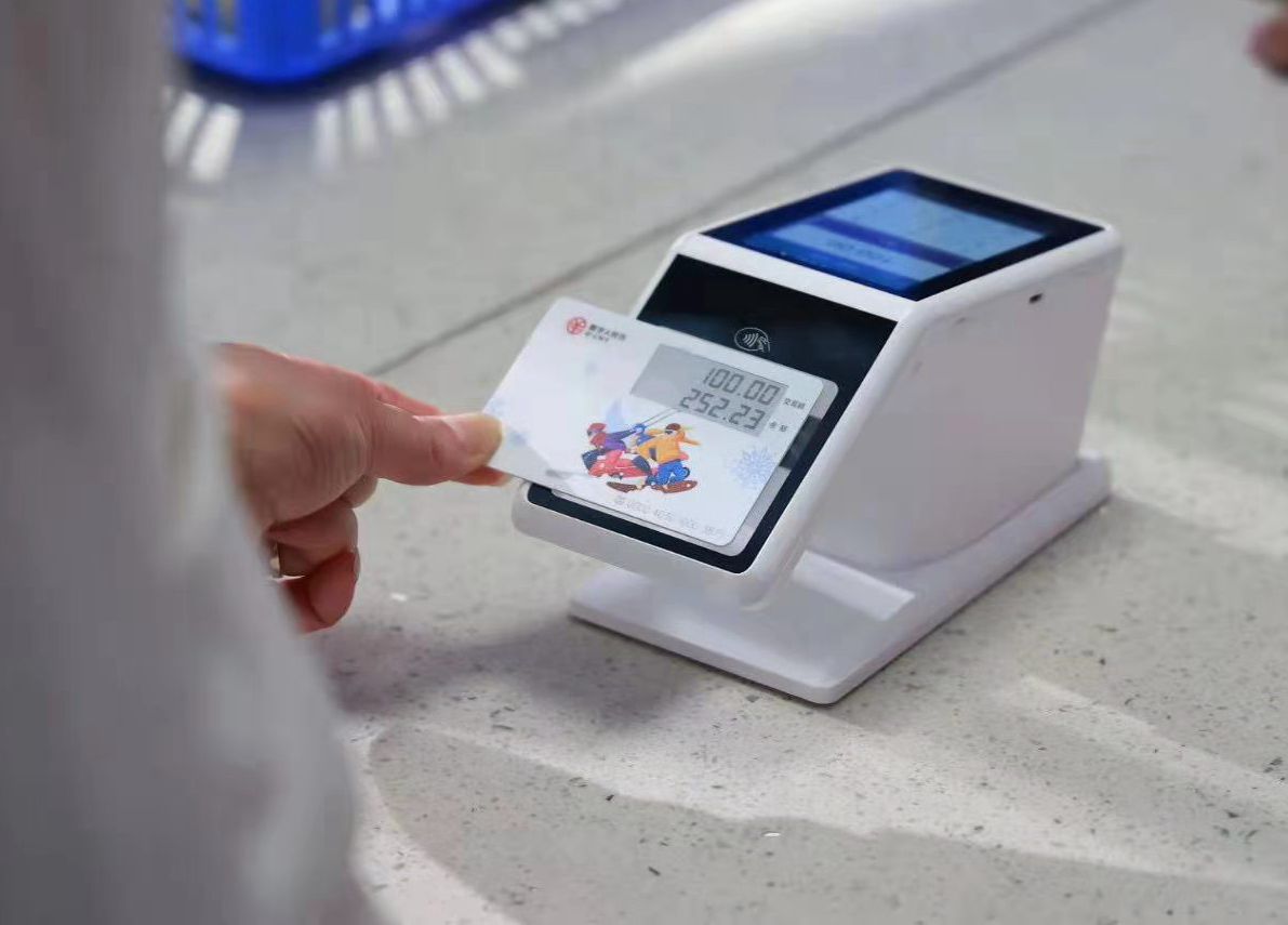 图为银行工作人员展示数字人民币卡式钱包使用方法.
