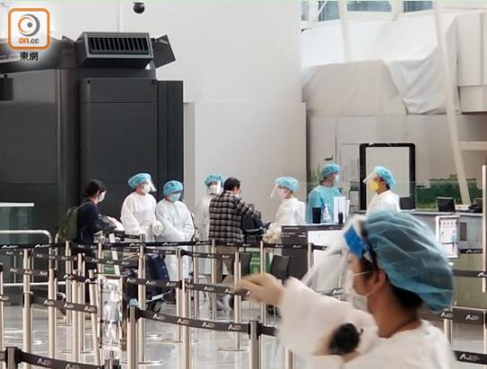 旅客按照工作人员指示进行登记检测。图自香港“东网”