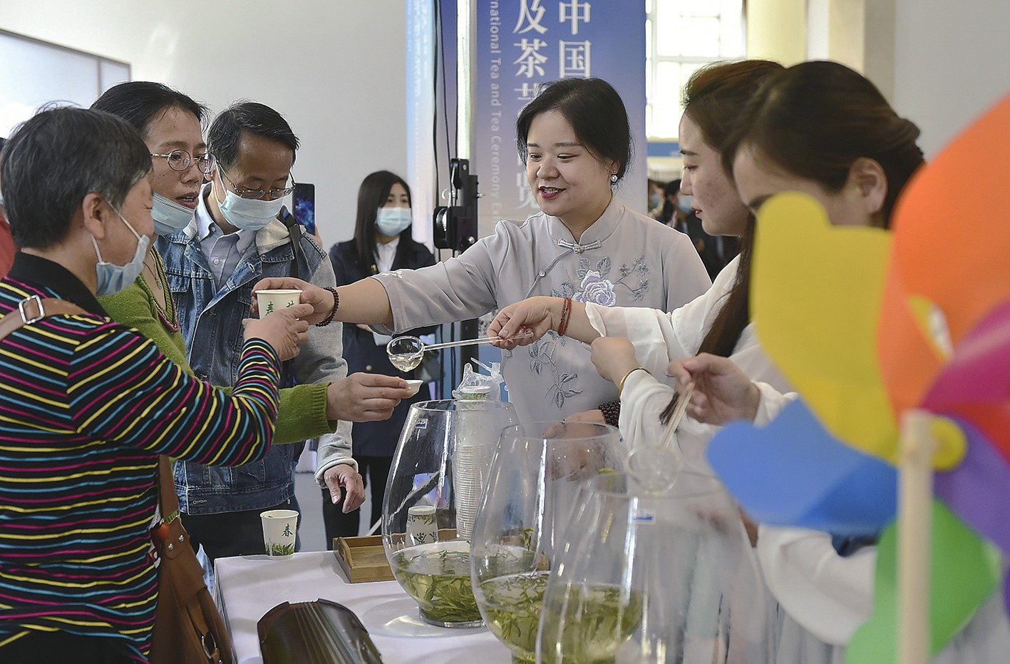 图为观众(左)在茶博会现场品尝春茶.