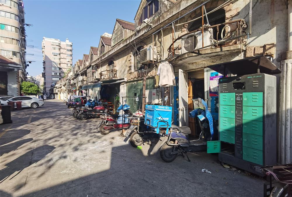 柳营路650弄y座门口,10多辆电瓶车一字摆开,一个高2米左右的换电柜