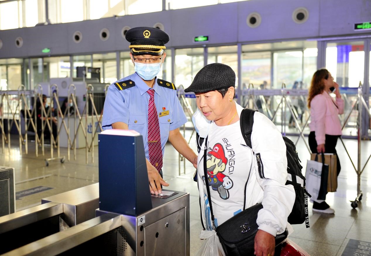 石家庄站客运员正帮助旅客检票进站.受访者供图