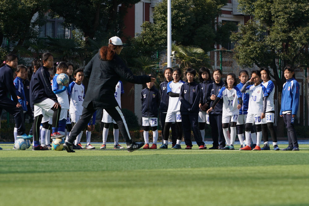 资料图：上海市梅陇中学女子足球队教练钱惠（前）在训练中指导队员。新华社记者丁汀摄