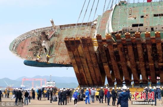 资料图：当地时间2018年5月10日，在韩国木浦全罗南道木浦新港码头，“世越”号船体扶正作业在进行中，船体已被拉起至纵截面与地面呈40度左右。 图片来源：视觉中国