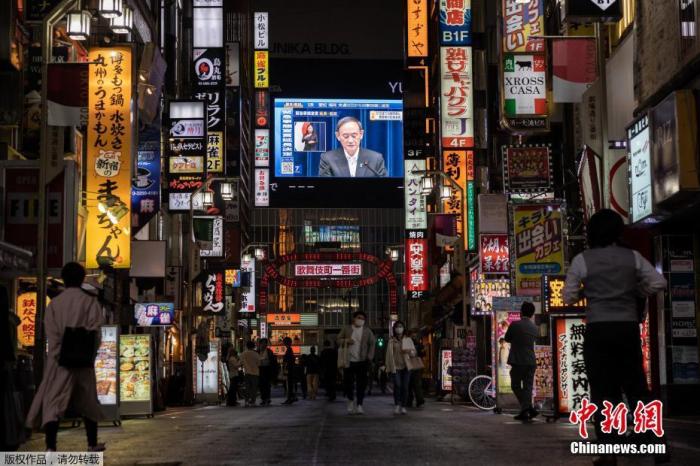 资料图:5月7日,日本政府正式决定将东京都、大阪府、京都府、兵库县4都府县正在实施的紧急状态延长至5月31日。图为东京街头大屏幕播放紧急状态延长的通知。