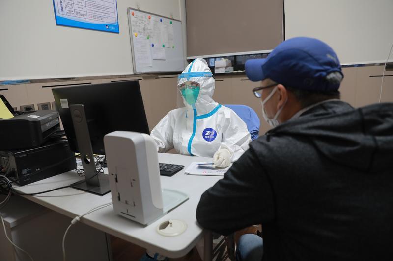 图说:在中山医院发热门诊,值班医生询问患者病情  朱依 摄