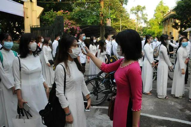 ▲资料图片：在越南首都河内的一所学校，学生们在参加开学典礼前接受体温检测。新华社记者 陶军 摄