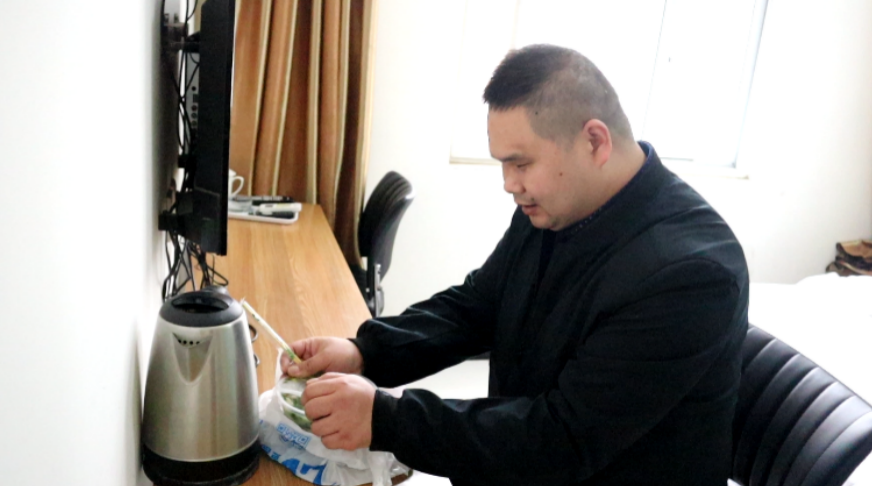 (图为王宝江在酒店品尝外卖下单的当地特色美食)