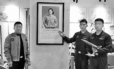     空军航空兵某旅飞行员和歼-20首飞试飞员李刚（左）一起，在“人民艺术家”常香玉挂像前合影。申进科摄/光明图片
