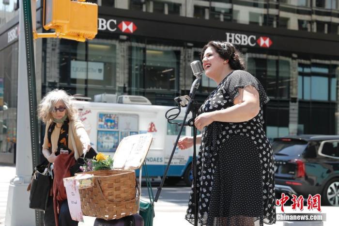 当地时间5月17日,美国纽约市联合广场一位艺人在路边歌唱。纽约州完全接种新冠疫苗的民众可不戴口罩、不保持社交距离,但在公共交通、养老院、监狱、学校等场所仍须戴口罩。 中新社记者 廖攀 摄
