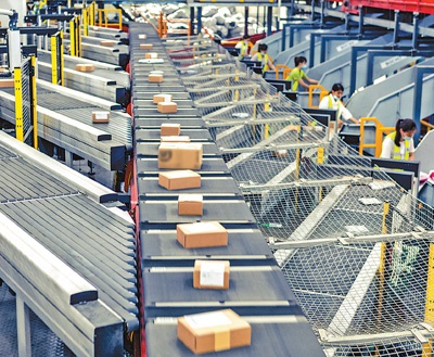 位于广州市黄埔区的一家快递公司分拨中心,工作人员正在有序分拣快递