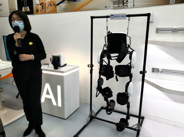 张江人工智能岛AI体验中心工作人员为记者讲解人工智能在医疗方面的应用，图为下肢外骨骼康复机器人。人民网记者 孙博洋摄